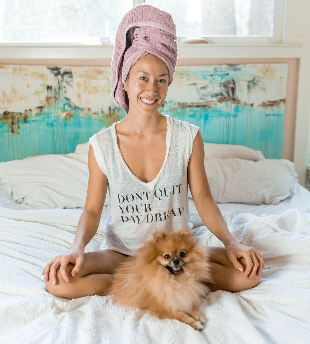 Happy woman with a towel on her head and her pet dog – Promoting natural hair care with Ayurvedic Herbal Hair Oil.