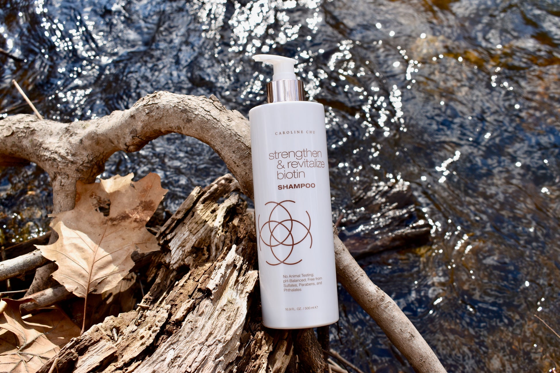 Biotin Strength & Revitalize Shampoo – eco-friendly packaging photographed in nature, promoting hydration and healthy hair.