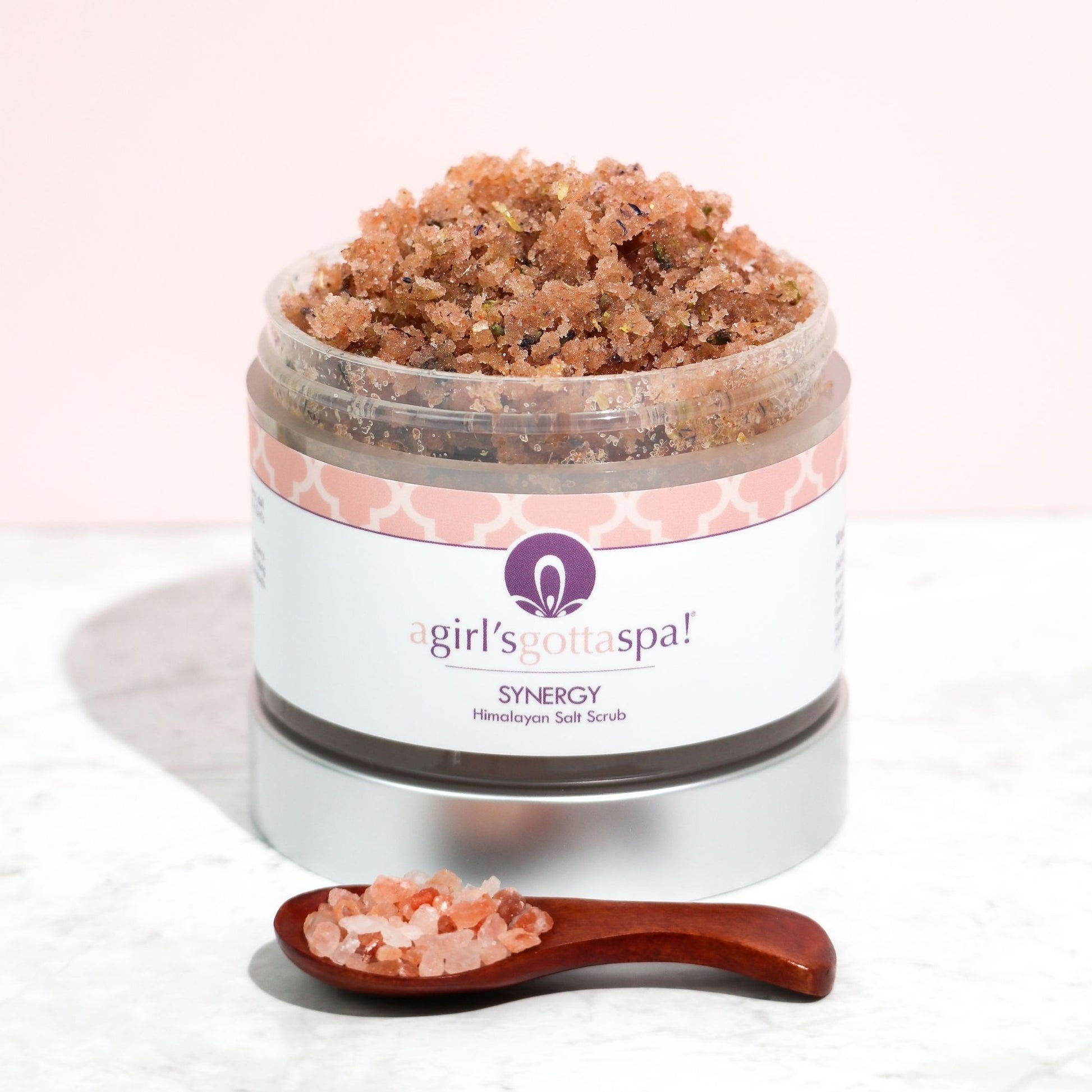 Open jar of Synergy Himalayan Salt Body Scrub with natural salt crystals – Luxurious skincare product.