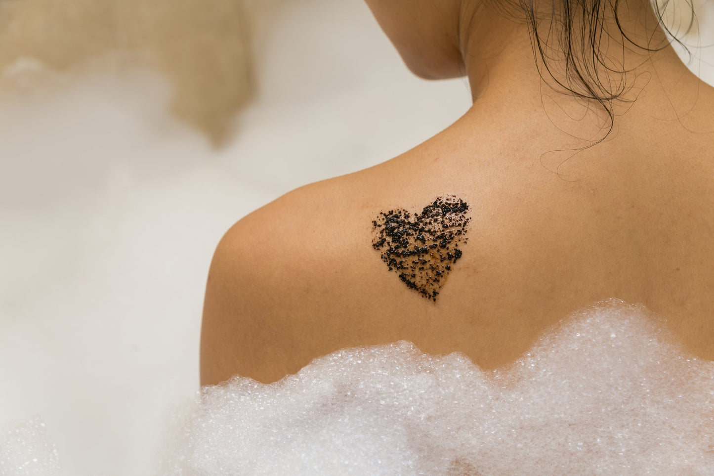 Coffee body scrub applied to the back in a heart shape, symbolizing natural skincare benefits.